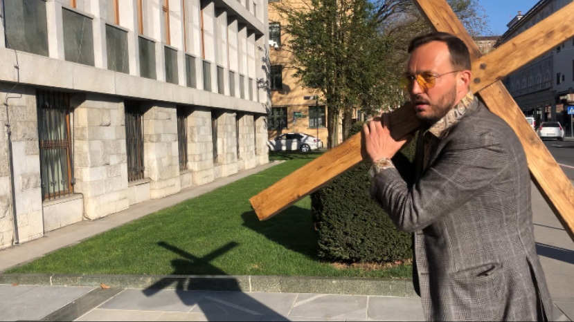 (VIDEO) Raper Zlatko v akciji pred parlamentom, pred katerega je prinesel lesen križ – Anis Ličina povedel protestnike na Trg republike in potem še pred RTV